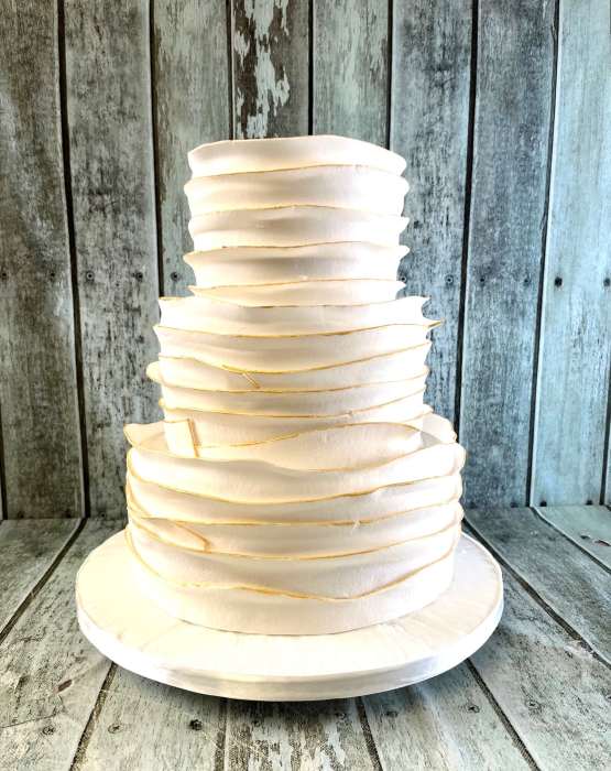 wedding-cake-with-icing-wraps-and-gold-tinted-edges