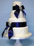 vintage lace and navy bow and brooch wedding cake