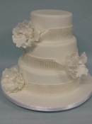 wedding cake with sashes and flowers