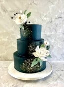 Dark green wedding cake with water Lilly\'s sugar flowers and hand painted gold gold 