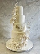 Tall wedding cake with oversized sugar flowers and ivy 