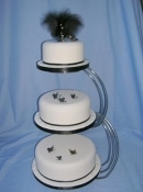 Round wedding cake on a stand with feathers and butterflys
