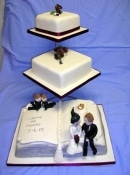 book and square wedding cake on a stand