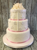 wedding cake with pearl buttons and lace